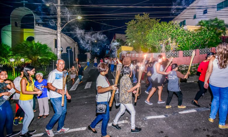 DEZENAS DE fiéis, segurando tochas, seguiram em cortejo até a Igreja Matriz