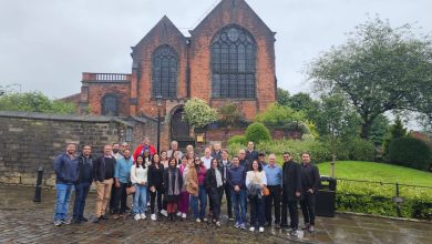 Grupo de participantes do evento 'Missão Raízes do Cooperativismo' em Manchester, Inglaterra, posando em frente ao Museu dos Pioneiros em Rochdale