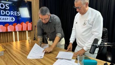 Gil Torres e Marco Barreto assinam carta em cima de uma mesa