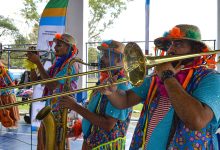 Homens fantasiados de palhaço tocam instrumentos.