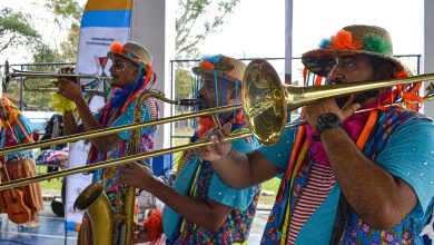 Homens fantasiados de palhaço tocam instrumentos.