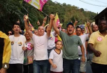 Aarão caminha na rua ao lado de vários entusiastas da sua campanha