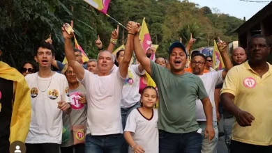 Aarão caminha na rua ao lado de vários entusiastas da sua campanha