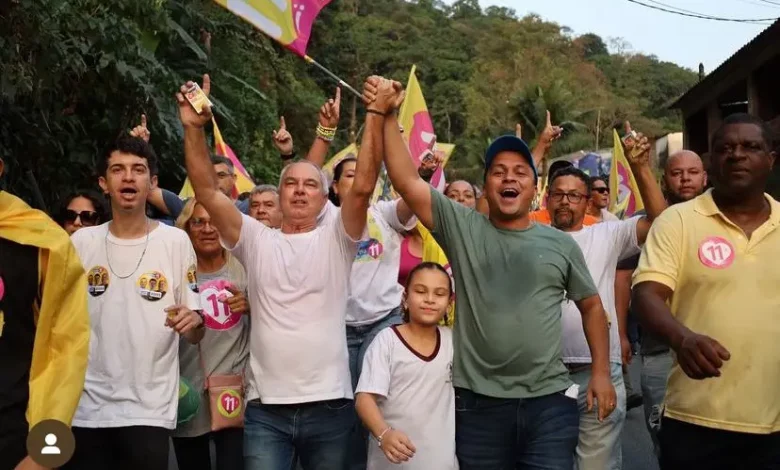 Aarão caminha na rua ao lado de vários entusiastas da sua campanha