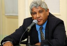 Anabal está de terno, sentado com as mãos escoradas sobre uma mesa e falando ao microfone