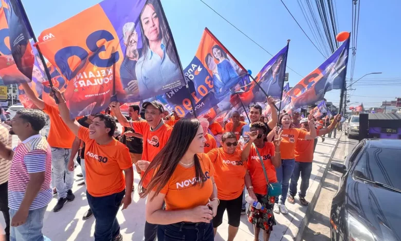 Kelaine cercada de bandeiras em caminhada de campanha em rua de Itaguaí.