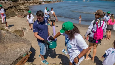 Voluntários catam lixo em uma praia em uma das edições do Clean Up Day