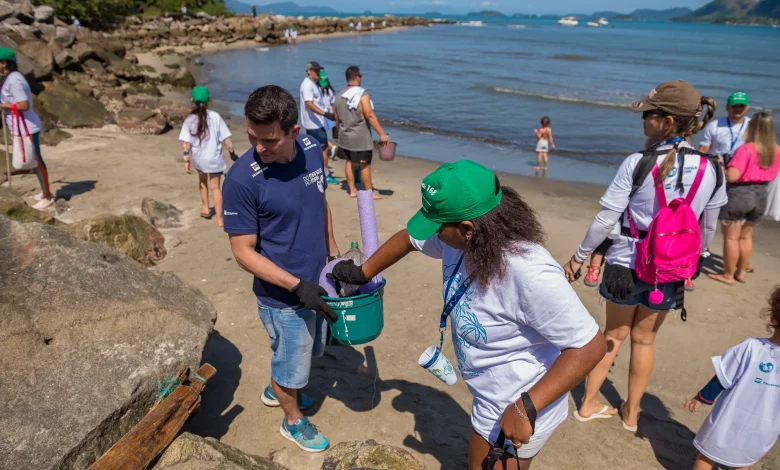 Voluntários catam lixo em uma praia em uma das edições do Clean Up Day