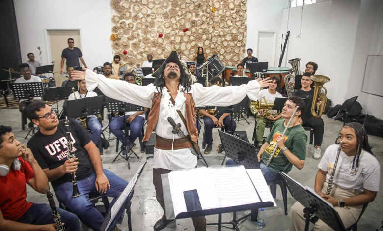 Músicos tocam com homem fantasiado de pirata do filme "Piratas do Caribe" no centro da roda de músicos