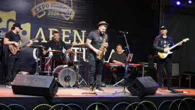 Igor Victor no palco, com músicos ao fundo.