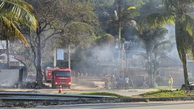 Foto mostra destruição da loja e carro de bombeiro parado ao lado.