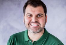 Luiz Cláudio, de camisa verde, sorri.