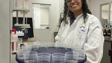 Thais Fernandes, Analista Master no Porto Sudeste, sorri no laboratório onde trabalha