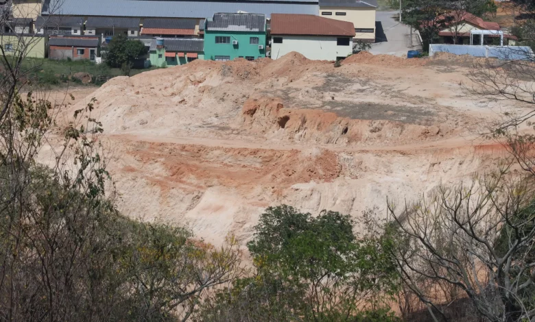 Terreno com desmatamento, corte total de áreas de morro, extração irregular de terra e movimentação do solo