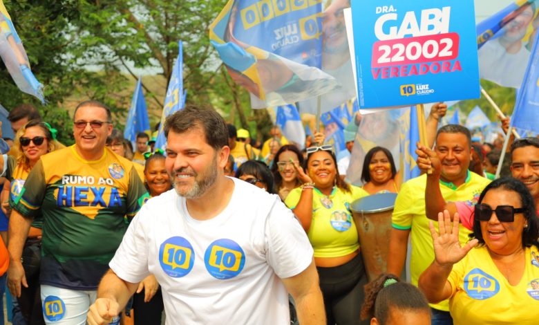 Luiz Claudio caminha em meio a entusiastas da sua campanha, na rua, em Mangaratiba