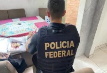 Policial observa mesa com documentos