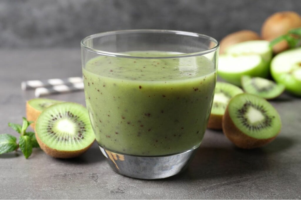 Copo de vidro com suco de kiwi com maçã verde 