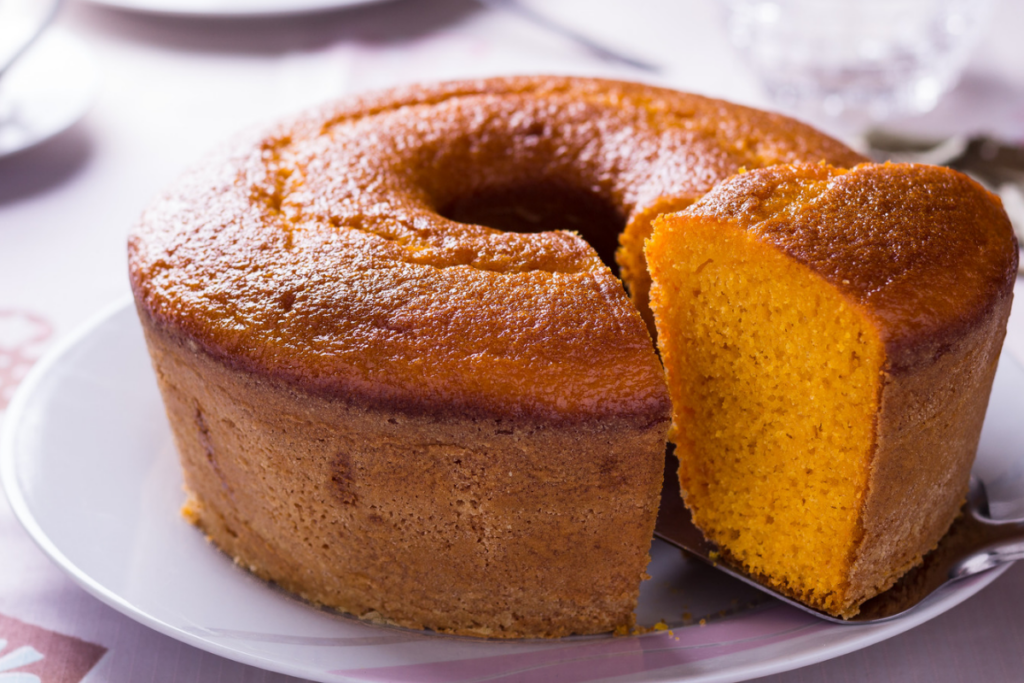 Bolo de cenoura em cima de um prato branco com um pedaço cortado