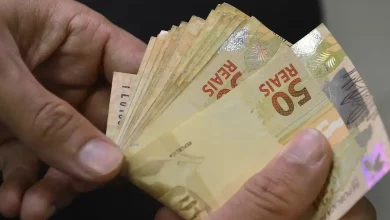 Pessoa contando dinheiro, várias notas de 50 reais