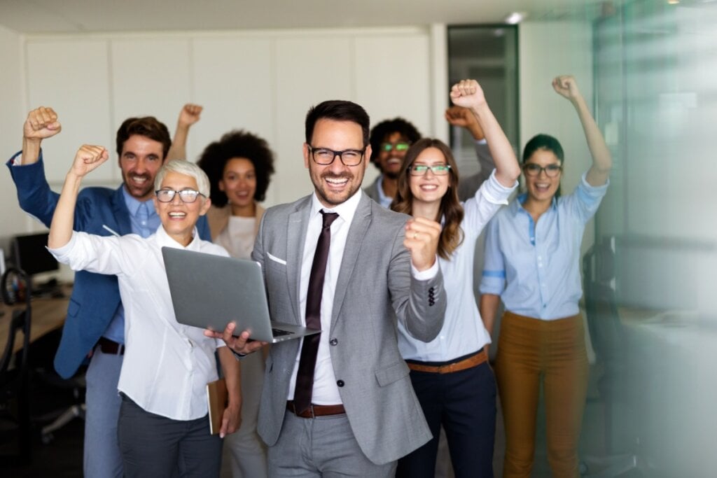 Líder com sua equipe no escritório fazendo uma comemoração