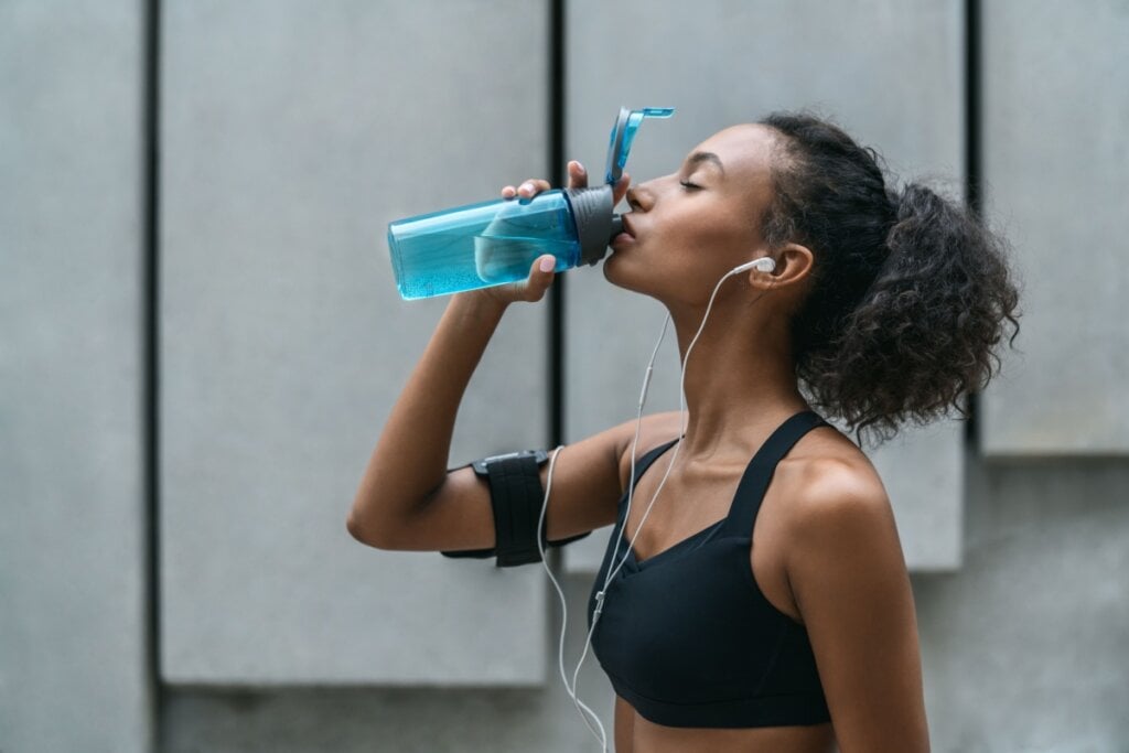 Mulher tomando água durante a corrida