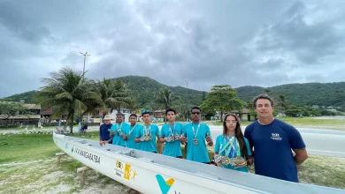 Equipe de atletas do projeto social "Remando para o Futuro" mostra com orgulho as medalhas