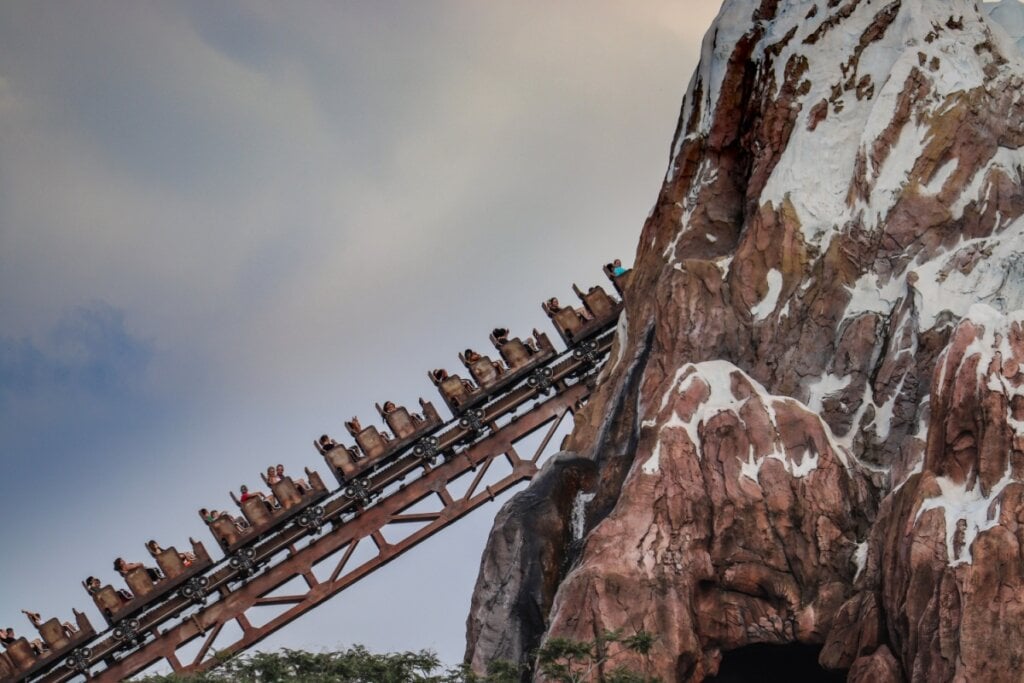 Imagem de montanha-russa subindo e entrando em grande montanha marrom e branca