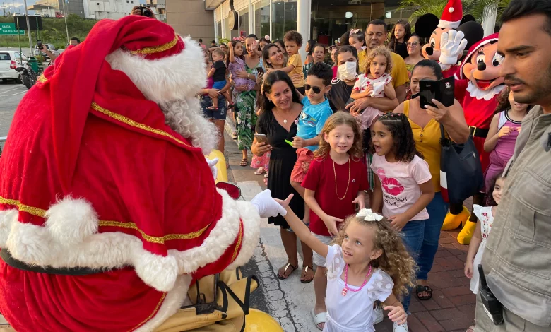 Pais e crianças recebem o Papai Noel no shopping