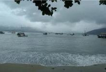 vista da praia do centro de mangaratiba mostrando embarcações, descrevendo o tempo fechado com nuvens carre3gadas
