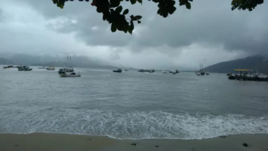 vista da praia do centro de mangaratiba mostrando embarcações, descrevendo o tempo fechado com nuvens carre3gadas