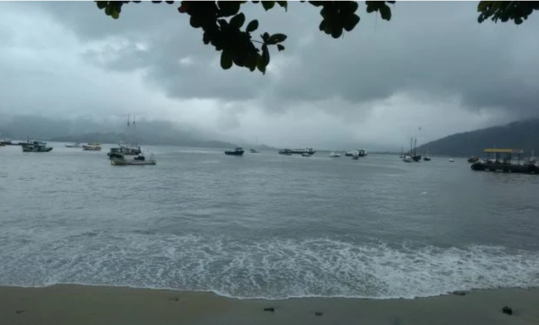 vista da praia do centro de mangaratiba mostrando embarcações, descrevendo o tempo fechado com nuvens carre3gadas