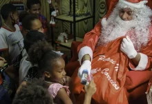 Papai Noel distribuindo brinquedos para as crianças