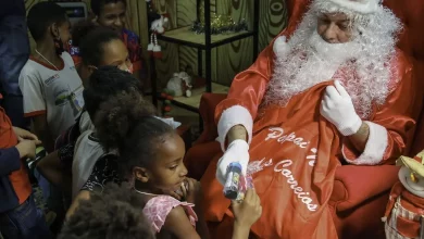 Papai Noel distribuindo brinquedos para as crianças