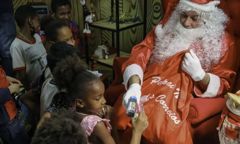 Papai Noel distribuindo brinquedos para as crianças