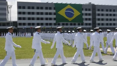 Marinheiros marcham com bandeira do Brasil ao fundo