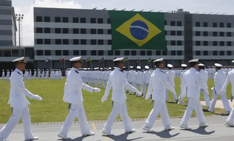 Marinheiros marcham com bandeira do Brasil ao fundo