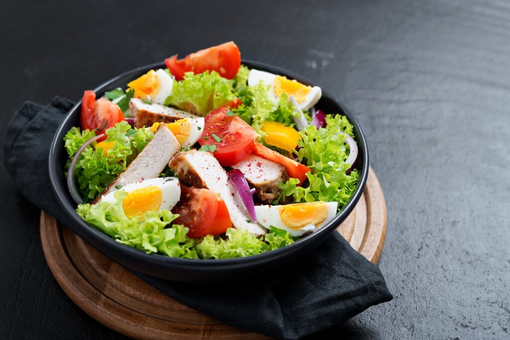 Salada de frango com ovo, alface, tomate e cebola