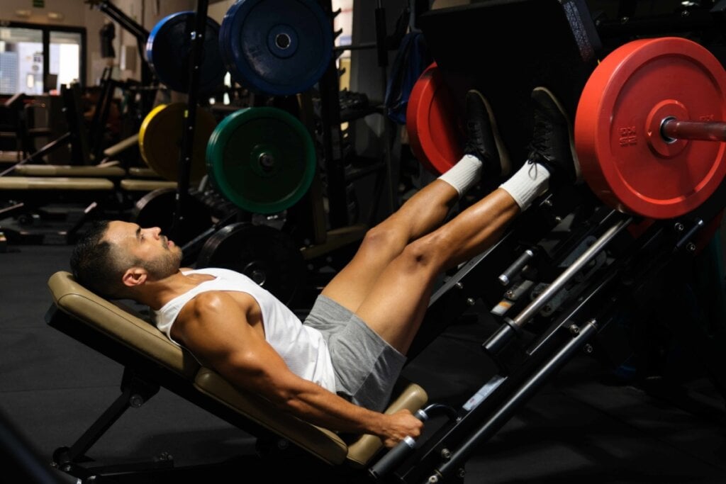 Homem fazendo exercício de musculação para as pernas na academia