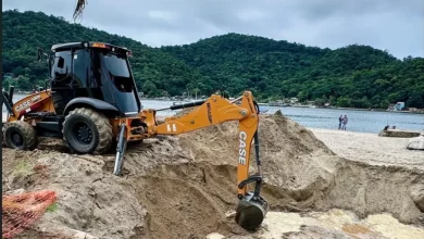 Máquina retroescavadeira realizando obras de saneamento na orla de Itacuruçá