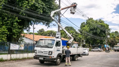 Caminhão com operário trocando lâmpadas