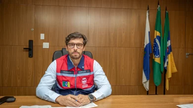 O prefeito de Itaguaí sentado à mesa posando para foto