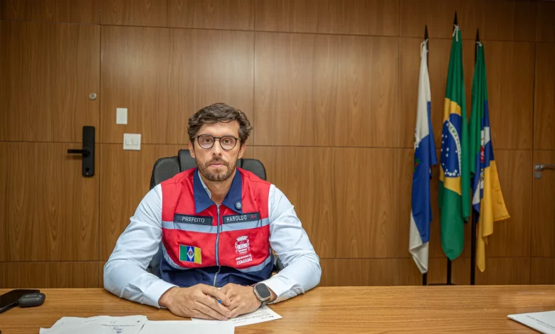 O prefeito de Itaguaí sentado à mesa posando para foto