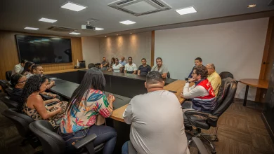 Pessoas ao redor de uma mesa participando de uma reunião