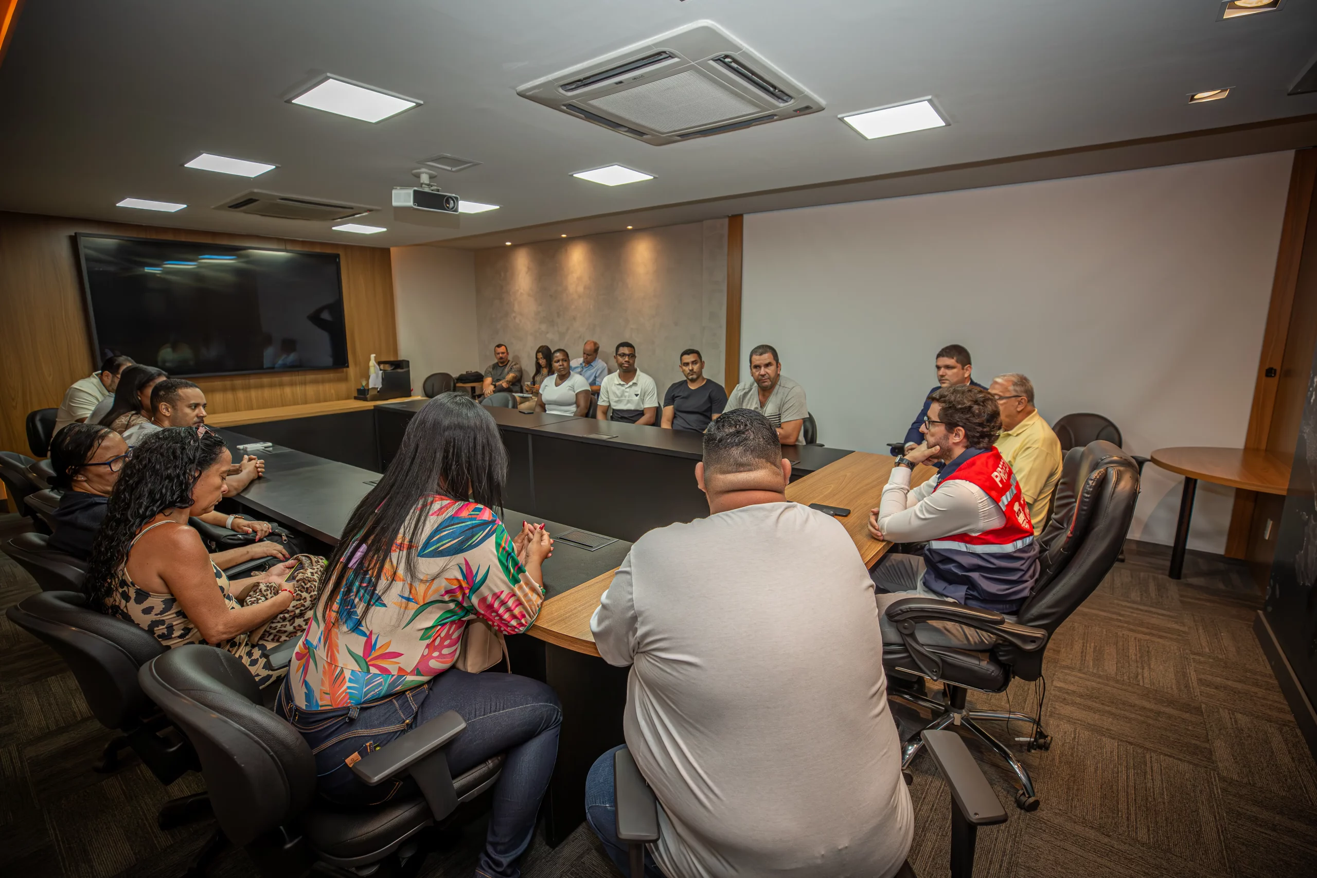 Pessoas ao redor de uma mesa participando de uma reunião