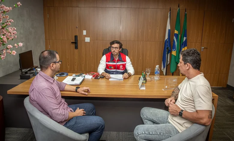 Dois assessores sentados à mesa com o prefeito de Itaguaí