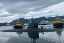 Submarino Tonelero é auxiliado por rebocadores na saída do cais