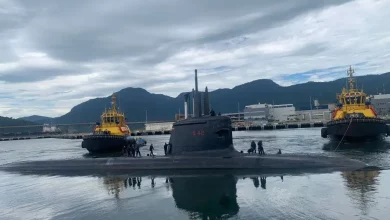 Submarino Tonelero é auxiliado por rebocadores na saída do cais