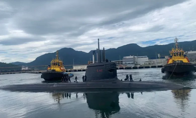 Submarino Tonelero é auxiliado por rebocadores na saída do cais