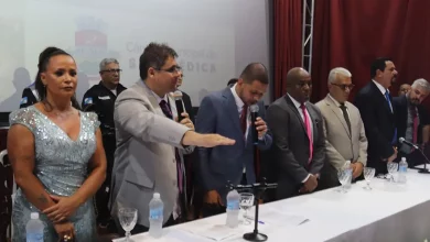 O prefeito presta juramento entre a vice-prefeita e o presidente do Poder Legislativo