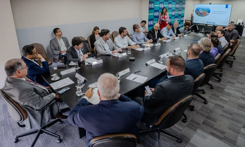 foto mostra iuma longa mesa com os participantes da reunião setorial